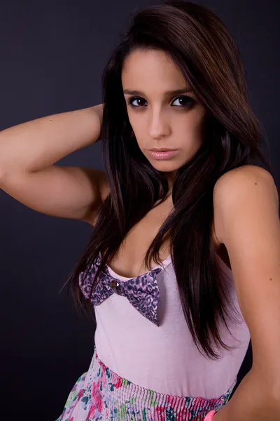 Mladá bruneta portrét proti černému pozadí — Stock fotografie