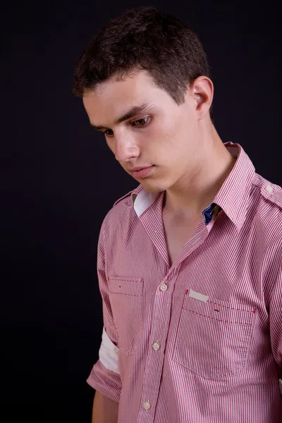 Young casual man against a black background — Stock Photo, Image