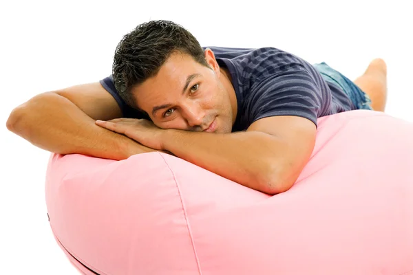 Young casual man seated in a small sofa — Stock Photo, Image