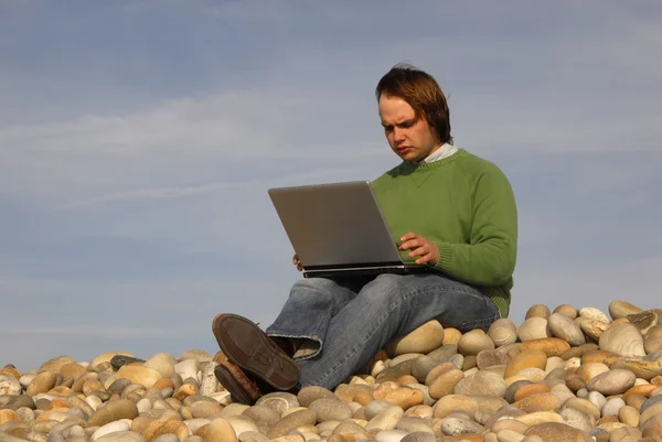 Giovane uomo casual con computer portatile in spiaggia — Foto Stock