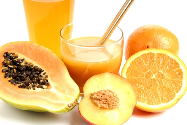 A glass of orange juice with cut oranges — Stock Photo, Image