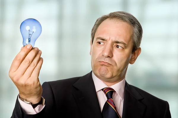 Reifer Geschäftsmann mit Lampe im Büro — Stockfoto