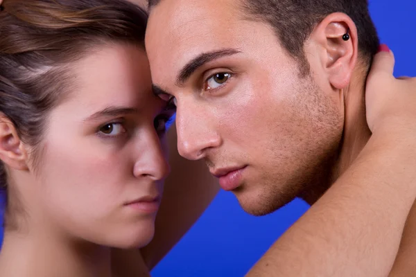 Young couple together portrait on blue background — Stock Photo, Image