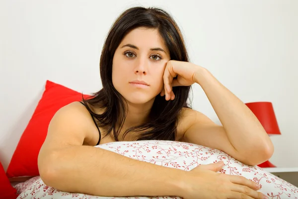 Young sad beautiful woman in bed, studio picture — Stock Photo, Image