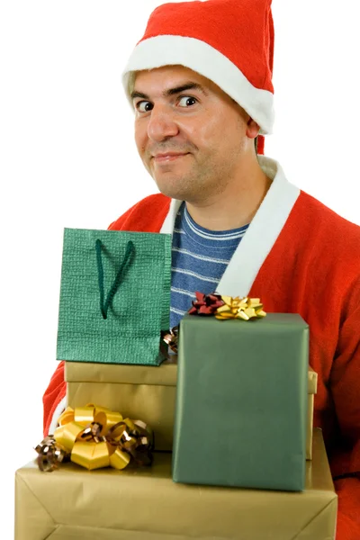 Young man with santa hat holding some gifts, isolated — Stock Photo, Image