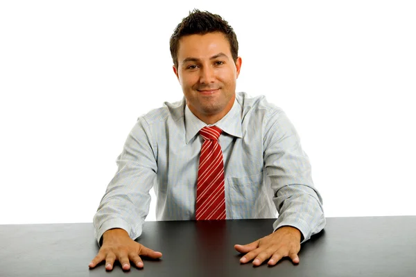 Junger Geschäftsmann auf einem Schreibtisch, isoliert auf weißem Grund — Stockfoto