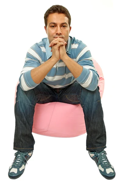 Young casual man seated in a small sofa — Stock Photo, Image