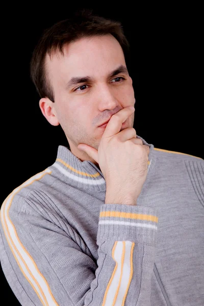 Young casual man thinking on black background — Stock Photo, Image