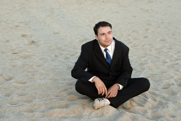 Joven hombre de negocios tonto en la playa con luz del atardecer —  Fotos de Stock