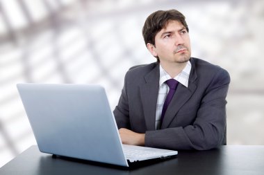 Genç iş adamı dizüstü bilgisayarla çalışıyor.