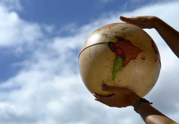 Globe in the woman hands and the sky — Stock Photo, Image