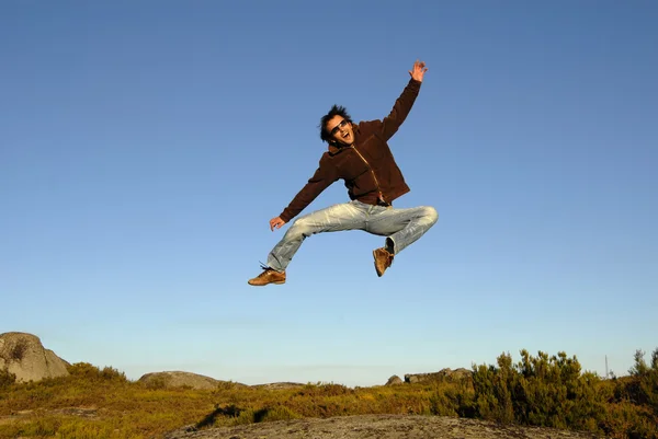 Jonge man springt hoog in de bergen — Stockfoto