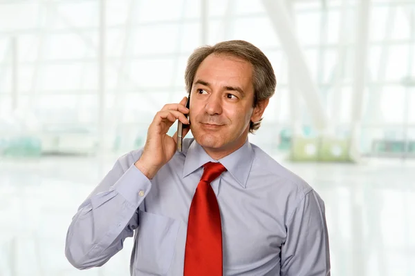 Mature man on the phone at the office — Stock Photo, Image