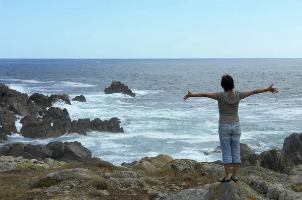 Femme heureuse avec les bras grands ouverts sur la côte — Photo