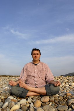 genç adam Sahilde meditasyon