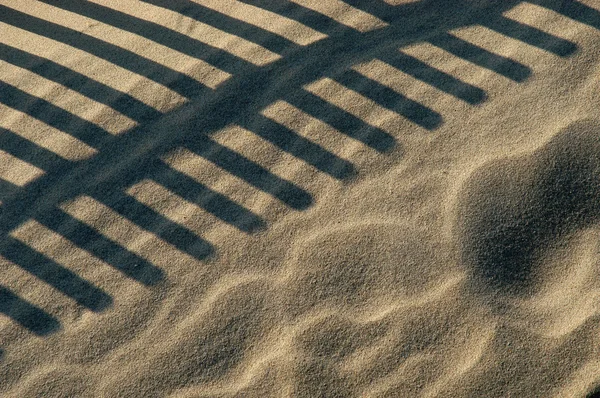 Заборная тень на песке — стоковое фото