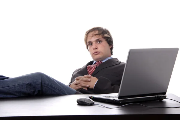 Junger Mann fragt sich, während er mit Laptop arbeitet — Stockfoto