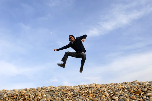 Jovem salta na praia — Fotografia de Stock