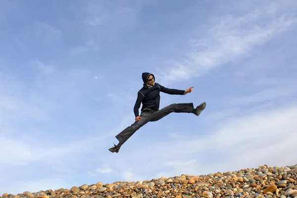 Jonge man springt op strand — Stockfoto