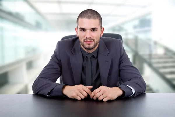 Junger Geschäftsmann auf einem Schreibtisch im Büro — Stockfoto