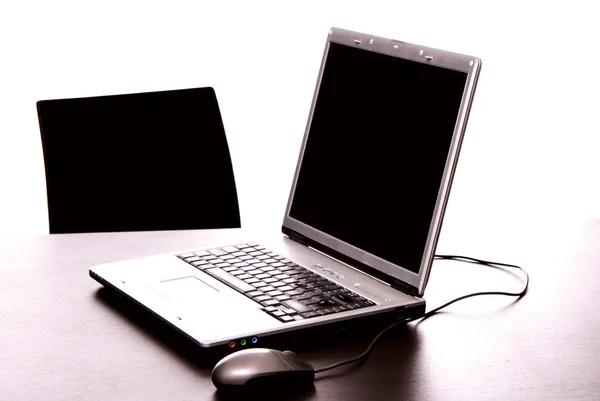 Zilveren laptop met de muis op een bureau — Stockfoto