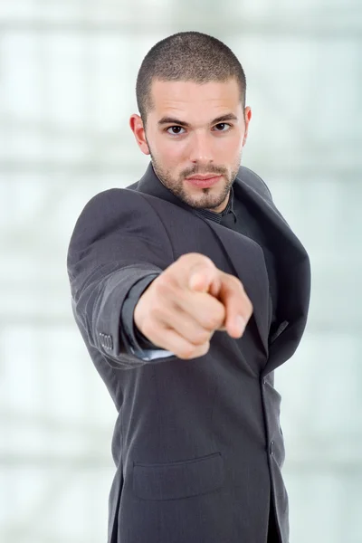 Jeune homme d'affaires en costume pointant du doigt — Photo