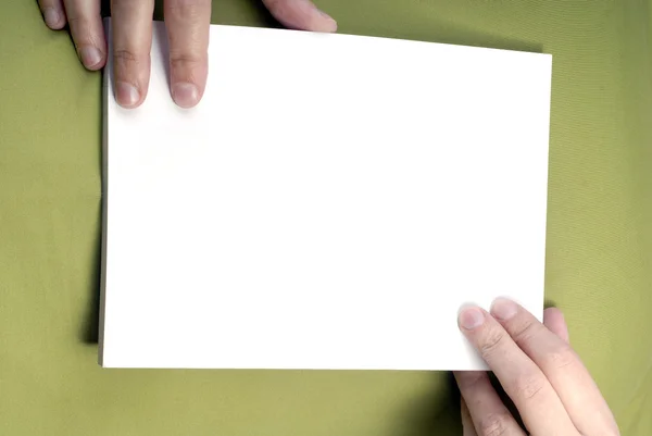 Mani di donna che tengono una carta vuota nel petto — Foto Stock
