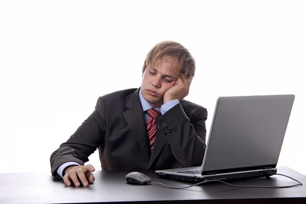Jeune homme d'affaires ennuyé travaillant avec est ordinateur portable — Photo