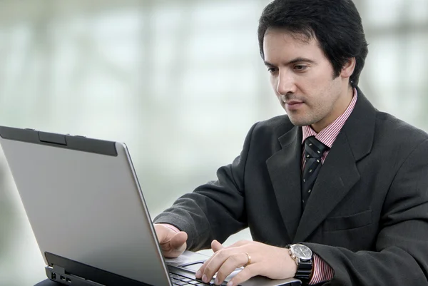 Hombre de negocios joven guapo que trabaja con el ordenador portátil —  Fotos de Stock