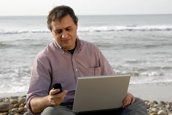 Jeune homme décontracté avec ordinateur portable à la plage — Photo