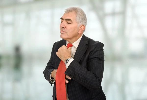 Business man adjusting his tie at the office — Stock Photo, Image