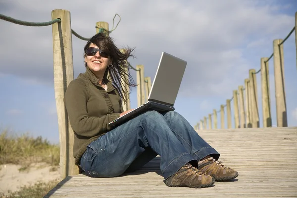 Junge glückliche Frau arbeitet mit ihrem Laptop — Stockfoto