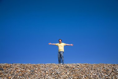Man with arms wide open at the beach clipart