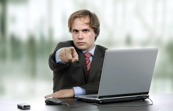 Młody człowiek wskazującego wile pracy z laptopem — Zdjęcie stockowe