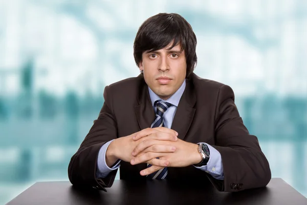 Young bored businessman on a desk at the office — Stock Photo, Image