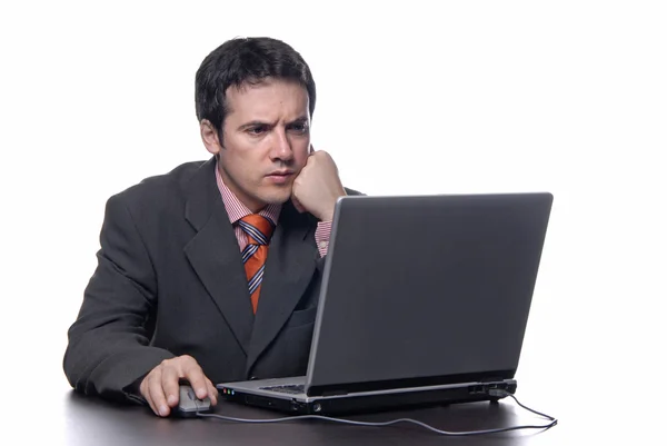 Jeune homme d'affaires ennuyé travaillant avec un ordinateur portable — Photo