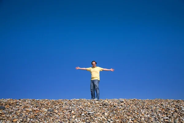 Man med armarna vidöppna på stranden — Stockfoto