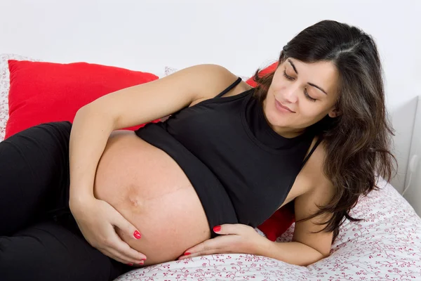 Młoda kobieta w ciąży w łóżku — Zdjęcie stockowe