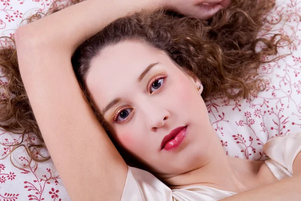 若い美しい女性がベッドに横たわっている — ストック写真