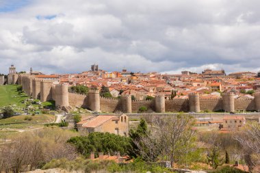 İspanya 'nın Cuatro Postes kentinin Mirador' undan ünlü ortaçağ kasaba duvarlarıyla tarihi Avila kentinin panoramik manzarası. UNESCO Dünya Mirası