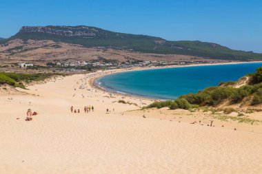 Tarifa, İspanya - Playa de Bolonia Plajı 'na yürüyen turistler, Tarifa, Cadiz' in bozulmamış beyaz kumsalı. Endülüs, İspanya.