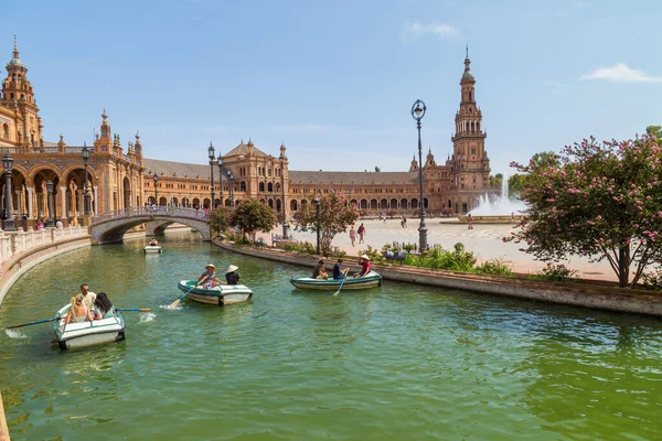 Seville, Endülüs, İspanya: Plaza de Espana Meydanı 'ndaki merkez Rönesans binası, Guadalquivir nehrinin gündüz tekneleri ve insanlarla manzarası.