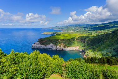 Azores 'deki Sao Miguel adasındaki Miradouro de Santa Iria' dan görüntü. Manzara, kuzey kıyı şeridinin bir kısmını uçurumları ve uçurumların üzerindeki yeşil alanları gösteriyor..