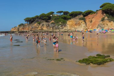 Albufeira 'daki ünlü Olhos de Agua plajındaki insanlar. Bu plaj Algarve 'nin ünlü turistik bölgesinin bir parçasıdır..