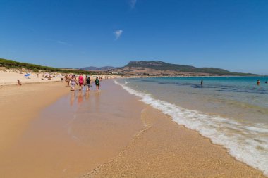 Tarifa, İspanya - Playa de Bolonia Plajı 'na yürüyen turistler, Tarifa, Cadiz' in bozulmamış beyaz kumsalı. Endülüs, İspanya.