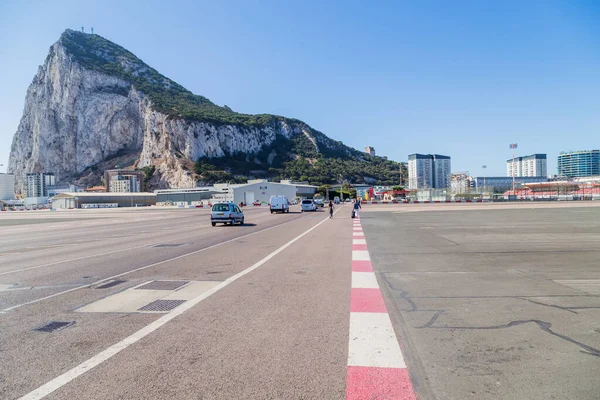 イギリスのジブラルタル ジブラルタル空港の滑走路を横断する地元の人や車とジブラルタルのロックを背景にしています ジブラルタル イギリス海外領土 イギリス — ストック写真
