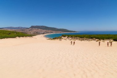 Tarifa, İspanya - Playa de Bolonia Plajı 'na yürüyen turistler, Tarifa, Cadiz' in bozulmamış beyaz kumsalı. Endülüs, İspanya.