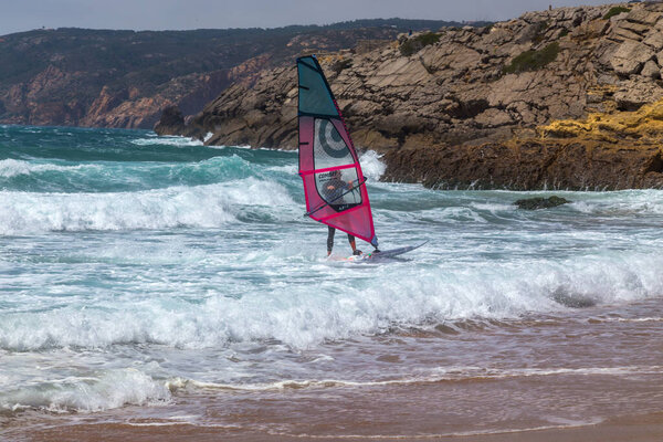 летние виды спорта: серфинг, катающийся на волне в солнечный день на голубом океане Гинчо, Португалия.