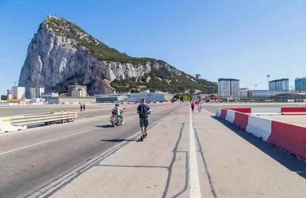 イギリスのジブラルタル ジブラルタル空港の滑走路を横断する地元の人や車とジブラルタルのロックを背景にしています ジブラルタル イギリス海外領土 イギリス — ストック写真