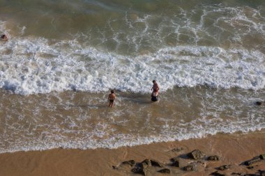 ALBUFEIRA, PORTUGAL - 22 Ağustos 2017: Albufeira 'daki Praia da Felesia' nın ünlü plajındaki insanlar. Bu plaj Algarve 'nin ünlü turistik bölgesinin bir parçasıdır..